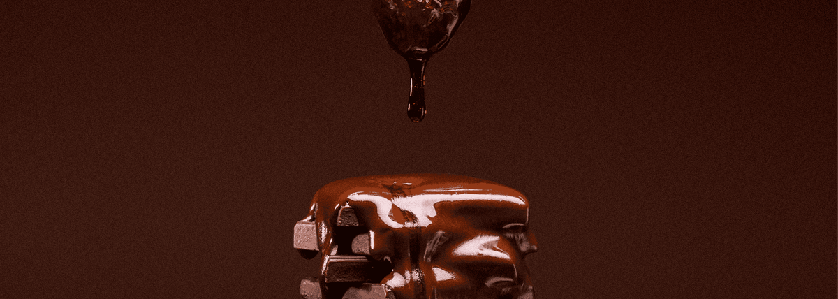 Chocolate being dripped onto a surface with a dark brown background